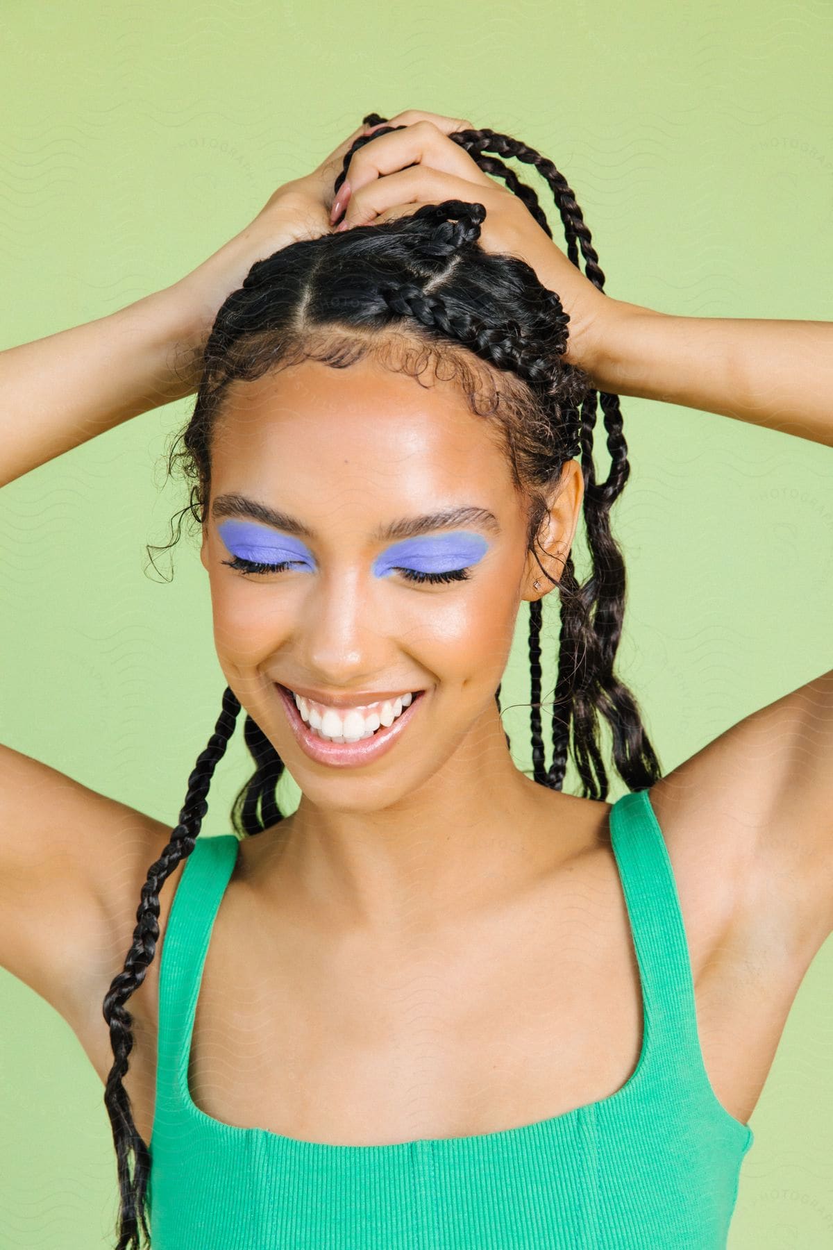 A young woman smiling, showing off her hair and makeup.