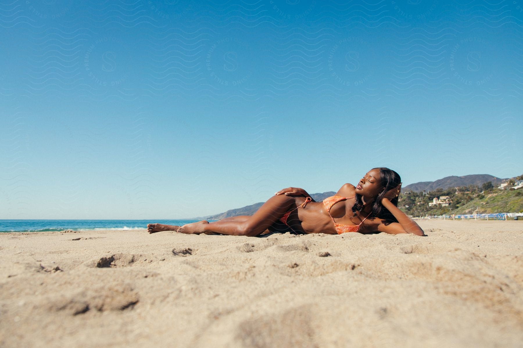 Woman lying in a bikini on the beach in the summer.