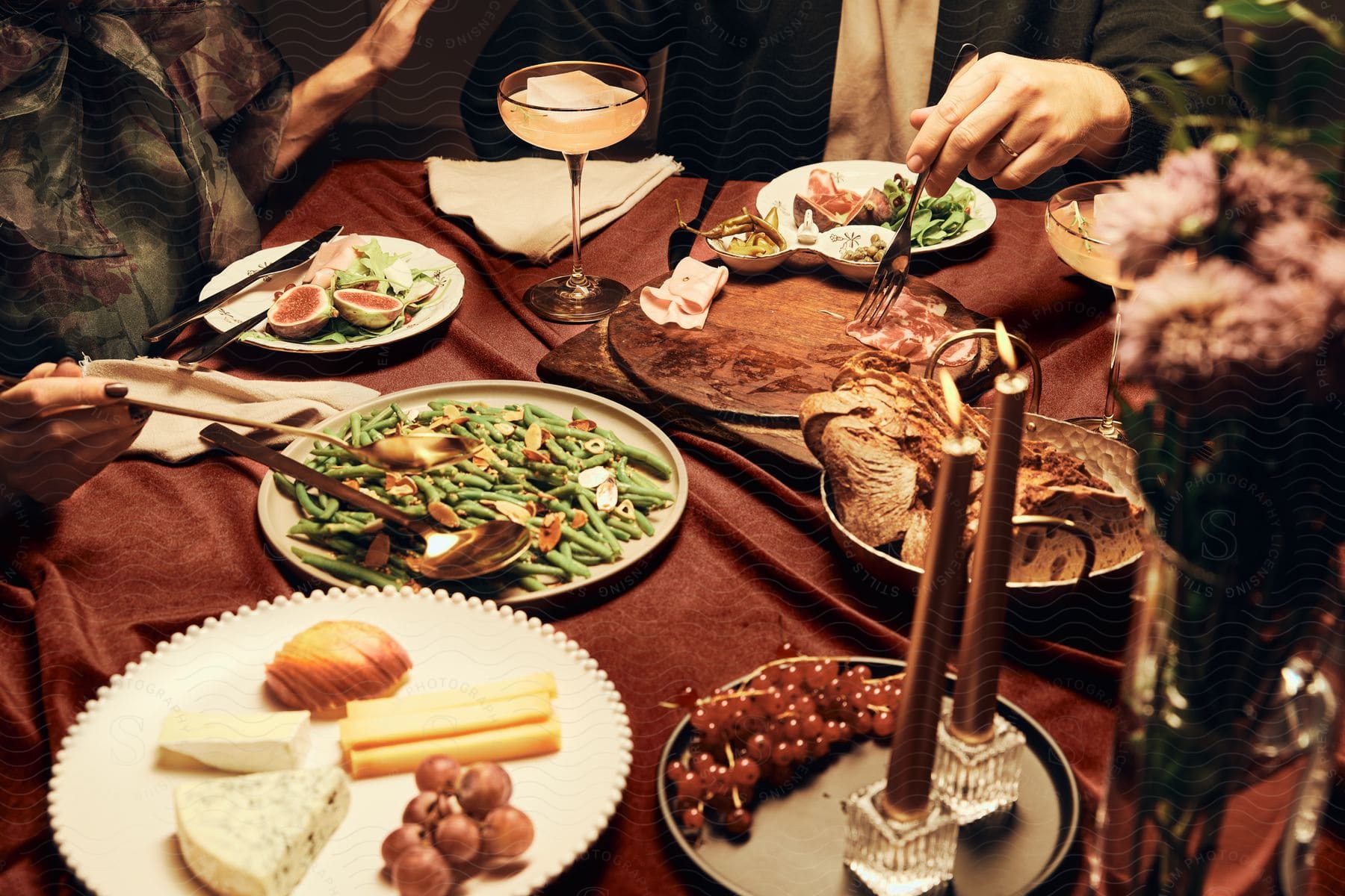 A woman and a man are enjoying drinks and appetizers at a restaurant table.