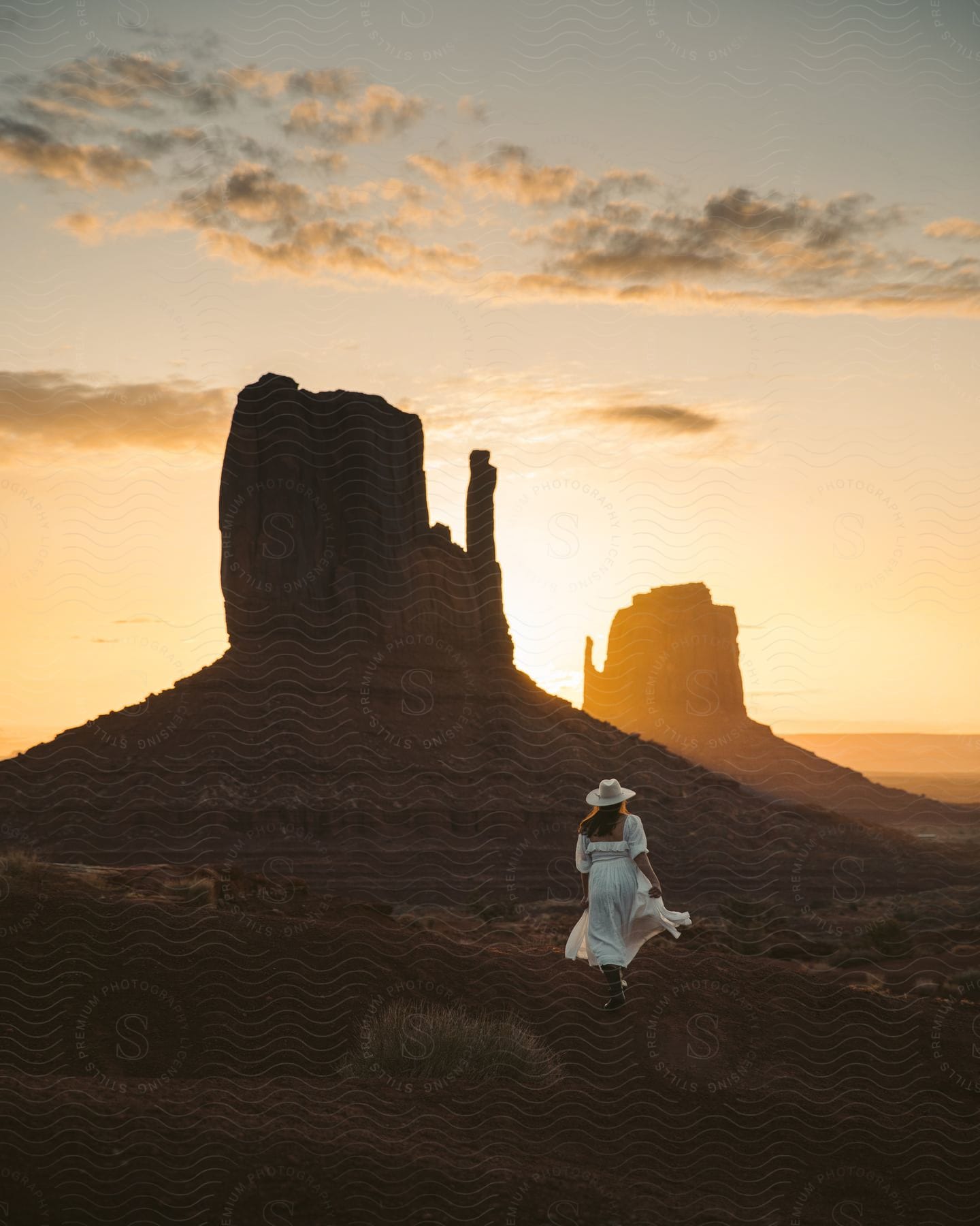 lady walk towards a mesa at sunset