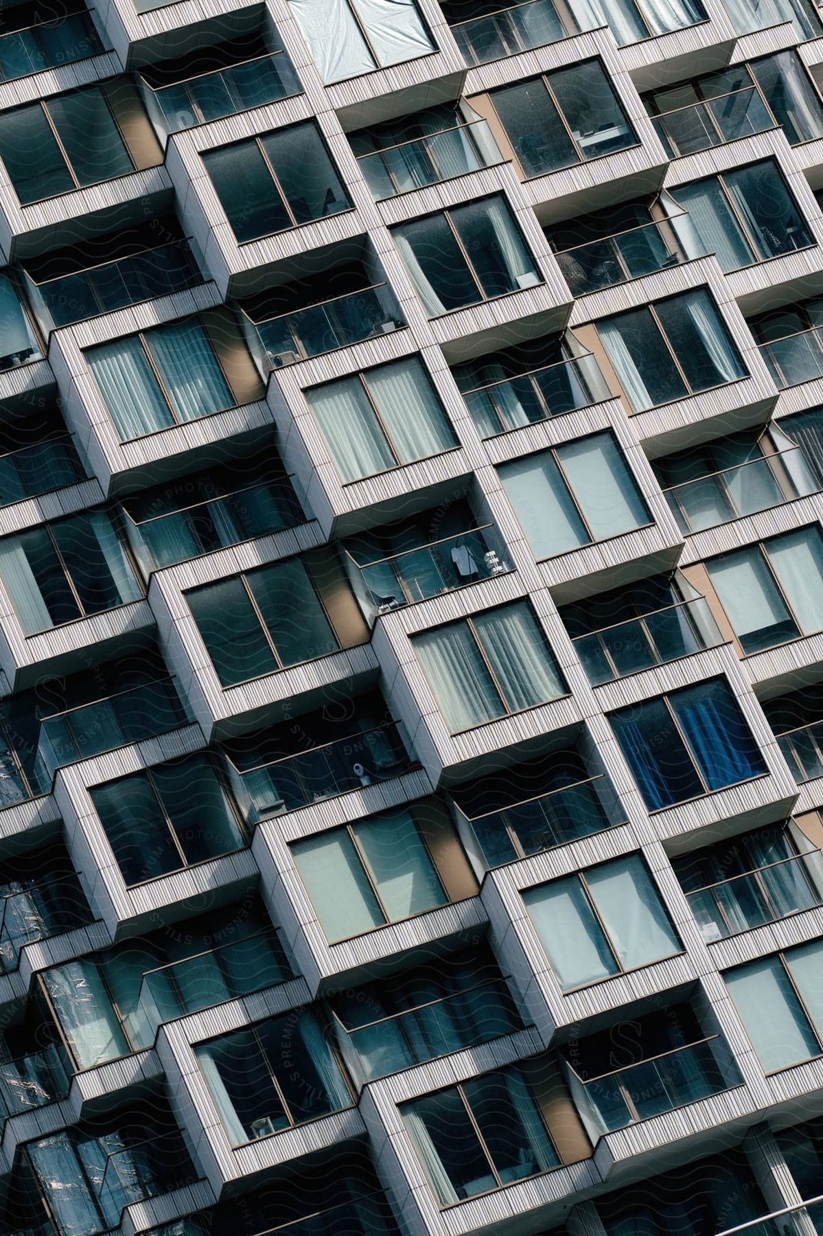 Curtains cover the apartment windows of a large apartment building