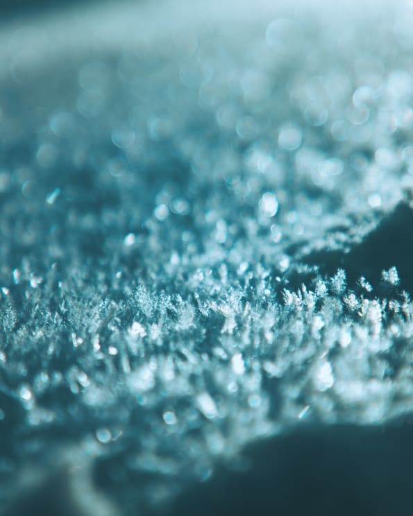 Delicate Ice Crystals Covering Ground Shine Under Electric Light At Night