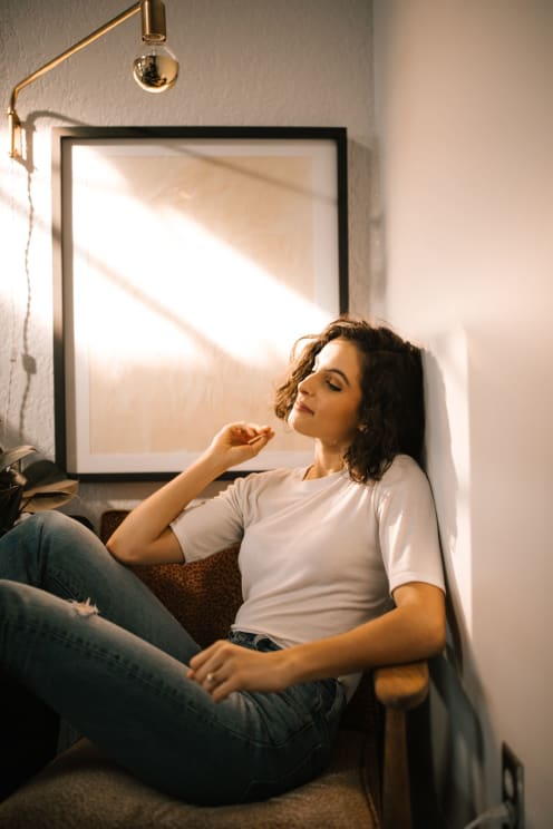 Brunette Woman With Short Hair, Wearing White Shirt And Jeans Poses