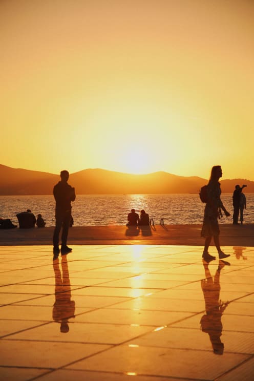 A Group Of People Sitting Outdoors Near The Ocean