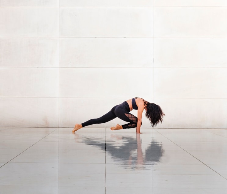 A Women Wearing Workout Clothing Is Stretching