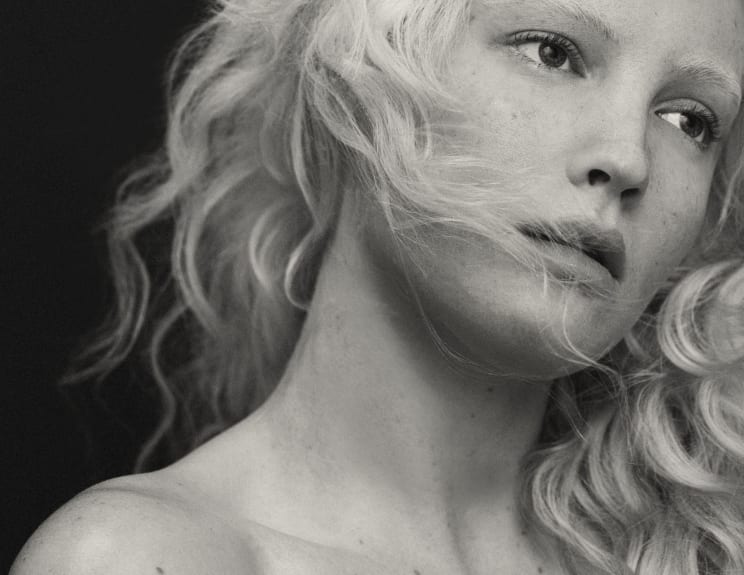 A Young Woman With Blond Hair And Freckles On Her Face