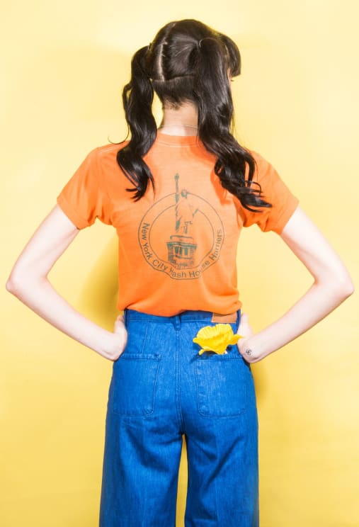 A Teenage Girl With Her Back Turned, Showing Off Her Statue Of Liberty T-shirt