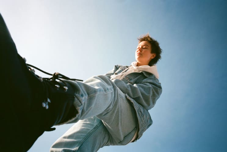 A Woman Is Wearing Jeans And Black Boots In Contrast To The Blue Sky