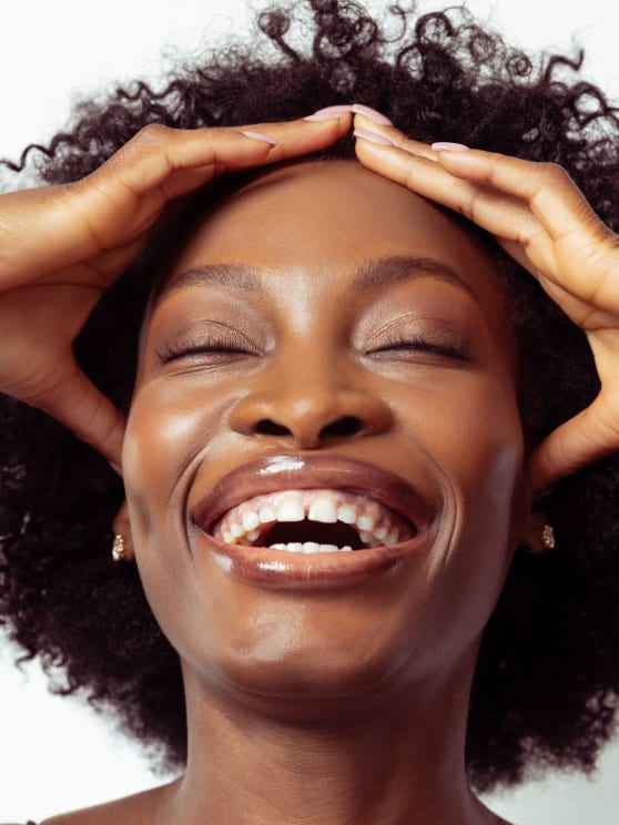 A Woman Holding Her Head And Smiling