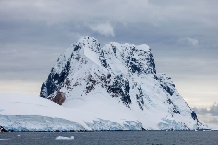 Arctic Sea Landscape With Icebergs And Snow-capped Mountains