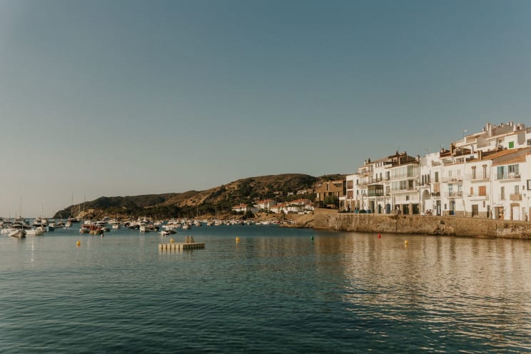 A Town On The Water That Has Many White Condo Buildings, And Many Boats Are On The Water