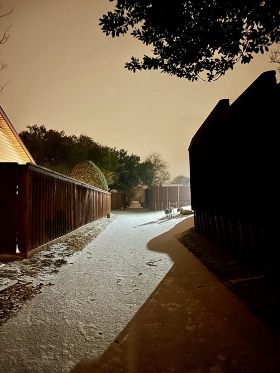 Street Covered By Snow In A Residential Neighborhood With Wooden Fences