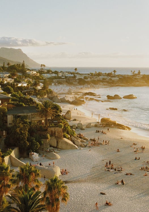 People On A Beach Next To A Tropical Coastal Town