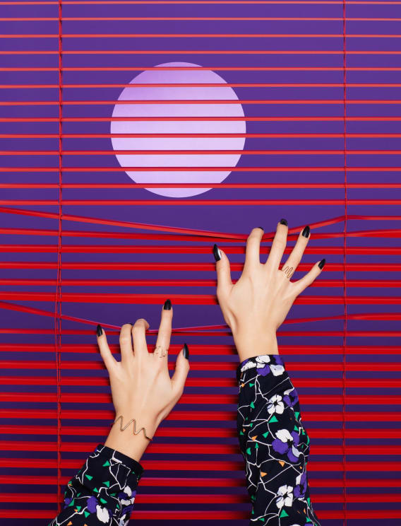 A Woman Reaching Into Some Blinds