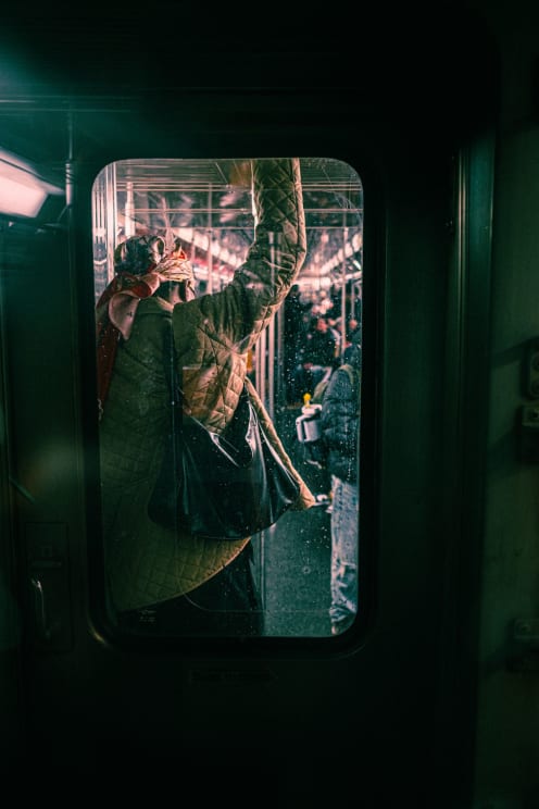 Woman Standing In A Subway Car With Her Purse Over Her Shoulder