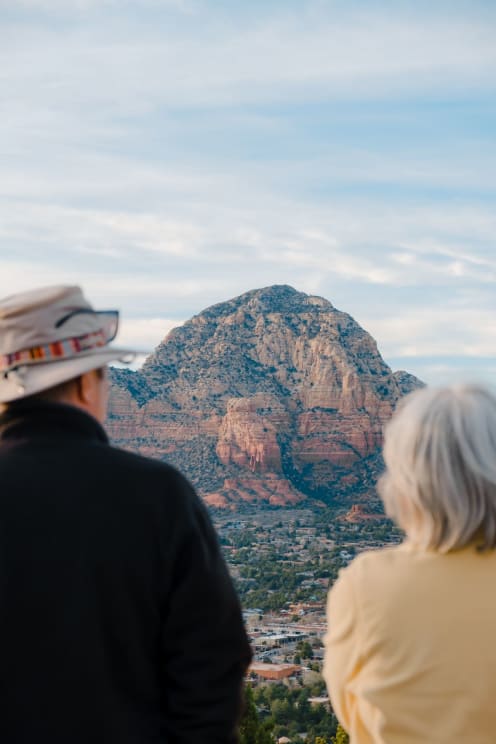A Man And Woman On Vacation Looking At A Mountain In The Distance
