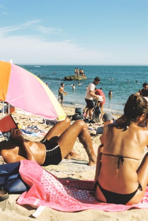 People Enjoying The Sun At The Beach