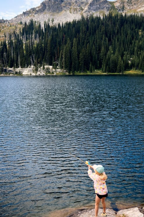 A Young Girl Fishing On A Forest Lake