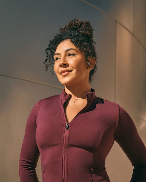 A Woman In A Maroon Zip-up Top