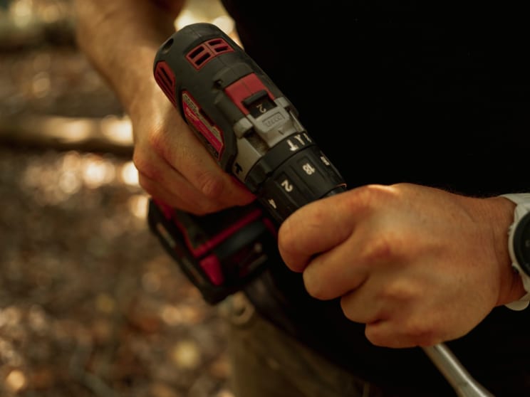 A Person Is Holding An Electric Drill