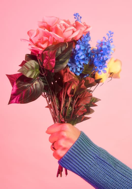 A Woman's Hand Holds A Bouquet Of Pink, Blue And Yellow Flowers