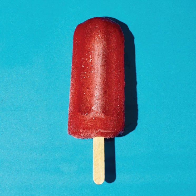 A Bright Red Popsicle Sits On A Blue Background