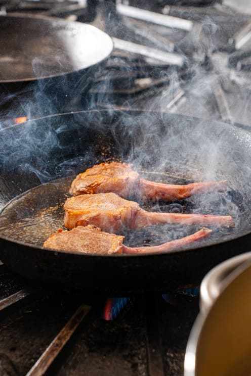 Smoke Rises As Lamb Chops Cook In A Pan