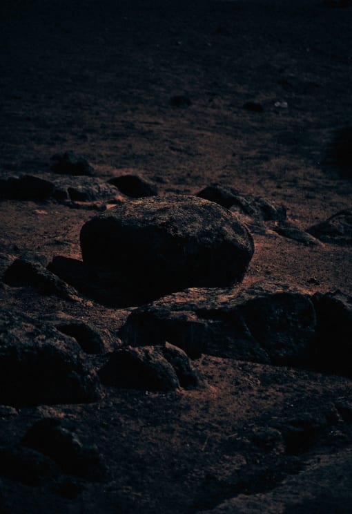 A Solitary Stone Stands Out In A Dark And Rocky Terrain