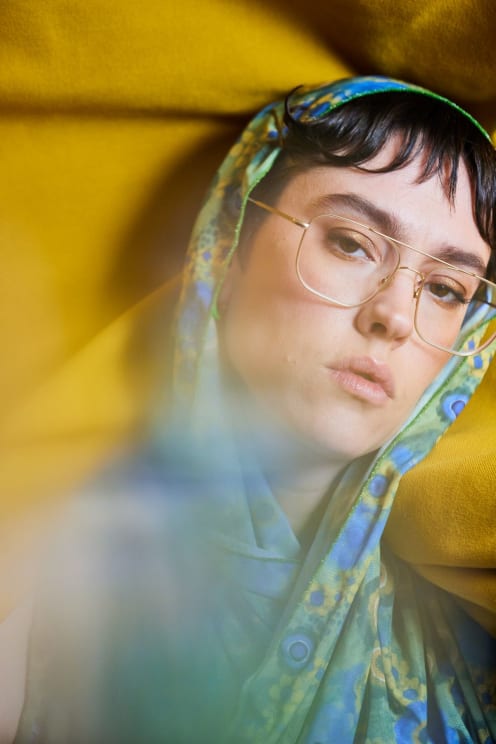 A Young Girl With Glasses And A Hoodie Stares Vacantly