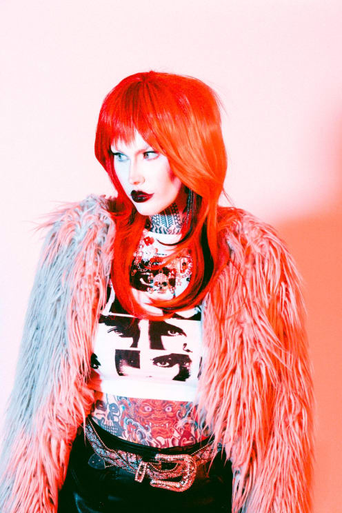 A Woman With Red Hair In A Neo Punk Outfit
