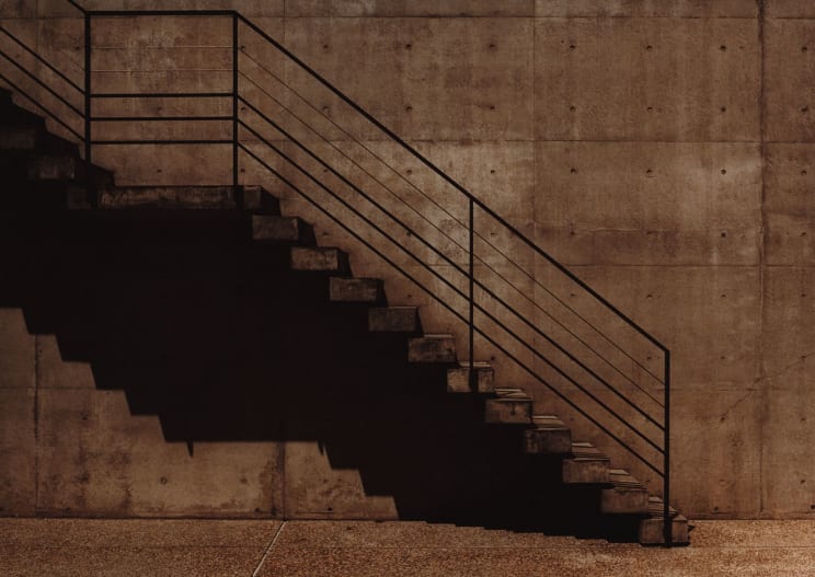 A Concrete Staircase Leads Upward, With A Steel Handrail Alongside It