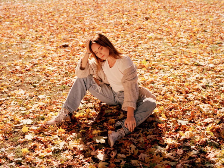 A Woman Sitting On Leafs