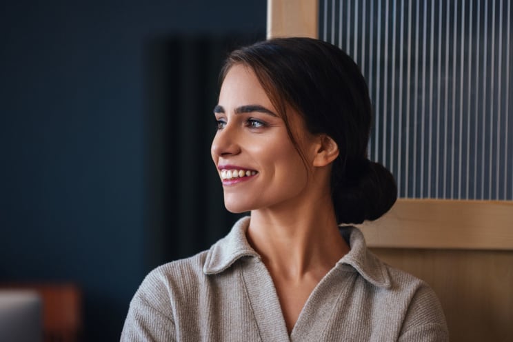 Smiling Woman Sits Near The Opening In An Interior Wall