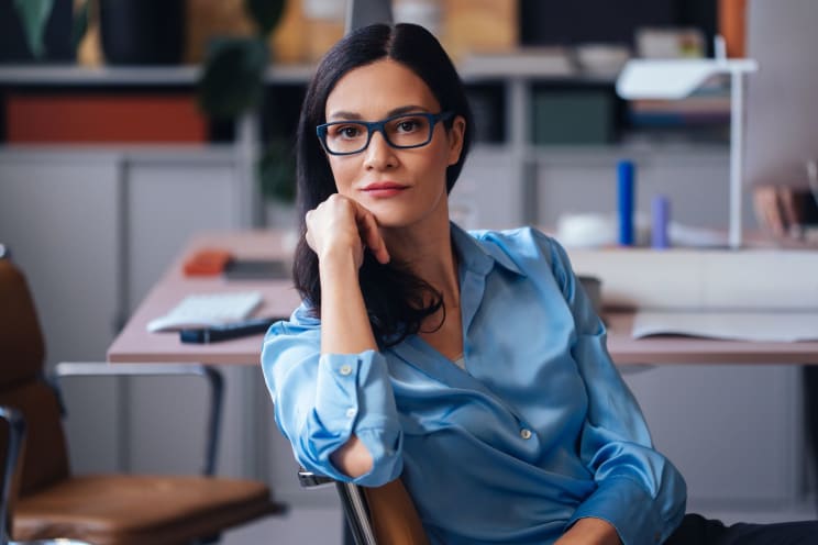 Woman Sitting In A Chair, Wearing A Blue Satin Shirt