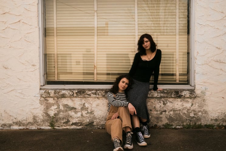 Two Women Sitting Outdoors On A Sunny Day