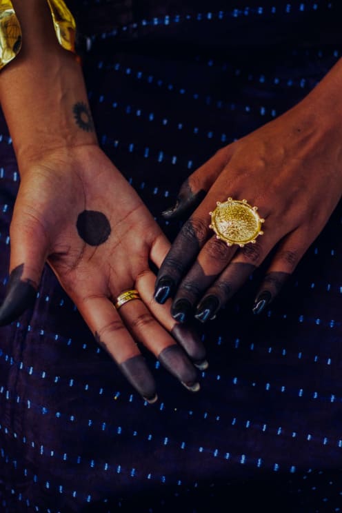 A Woman's Hands Are Shown With Her Nails Painted Black And A Black Design On Her Fingers