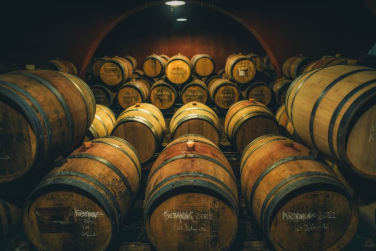 Rows Of Aged Wooden Barrels Lining The Walls Of A Dimly Lit Wine Cellar