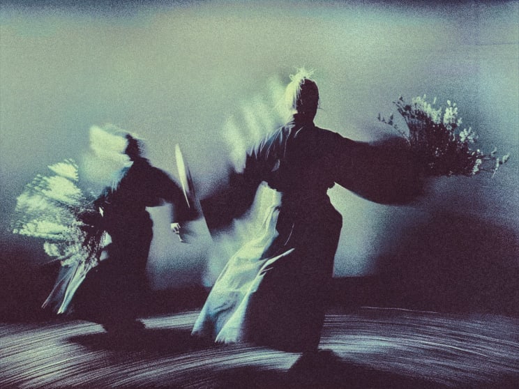 Two People Wearing Robes Move With Flowers