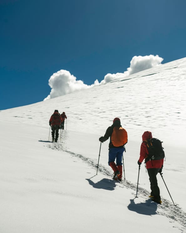 Group Of Four People Climbing A Snowy Mountain