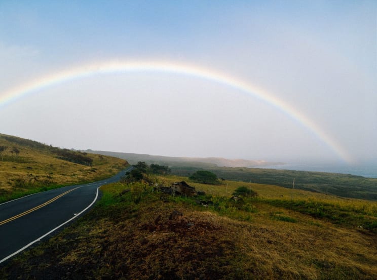 A Rainbow Over A Road In A Rural Area