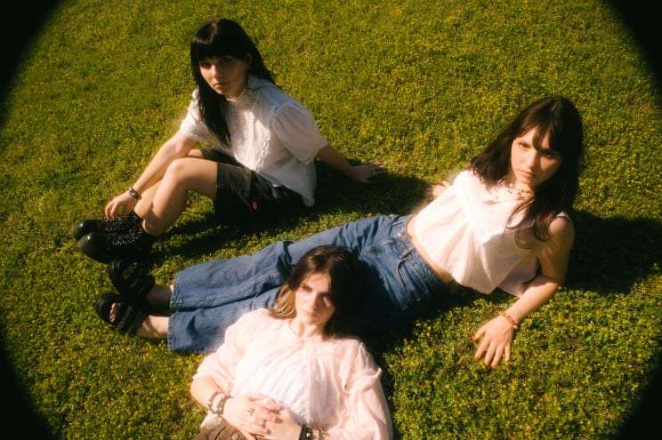 Three Women Laying In The Grass Outdoors