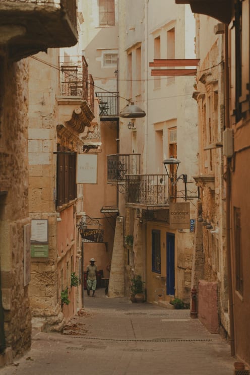 A Charming Narrow Street In An Old Town With A Man Walking