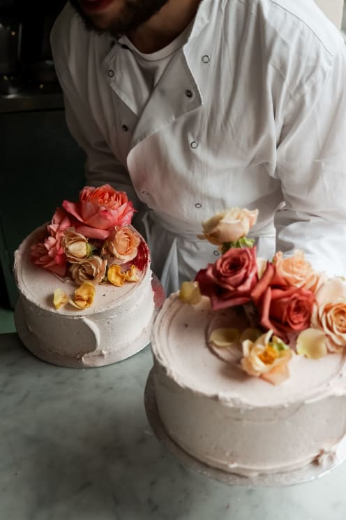 Baker Carrying Two Cakes Decorated With Roses