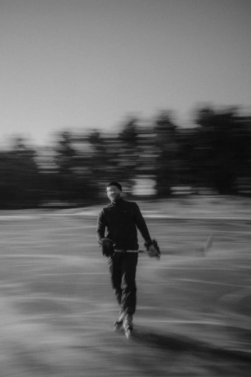 A Blurry Man Playing Hockey At Sunset