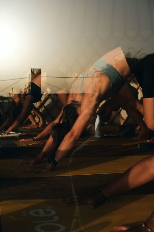Women In A Gym Behind A Glass, Doing Yoga Poses