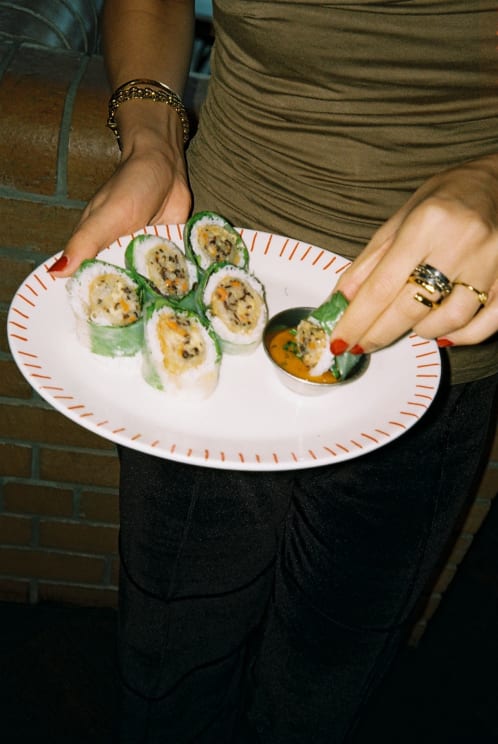 A Woman Eating Some Food While Standing Up