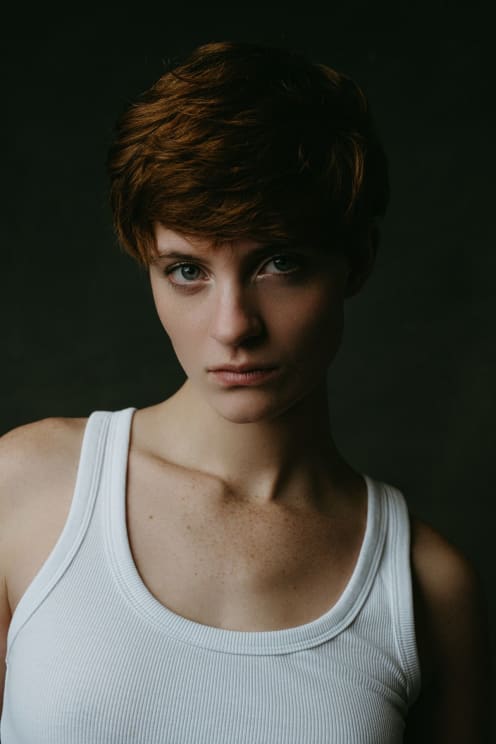 A Young Woman With Short Hair And Wearing A Tank Top