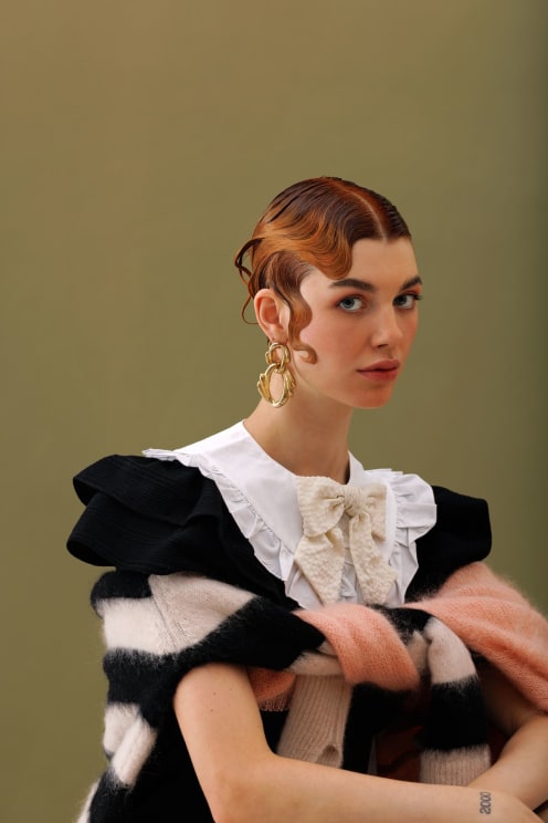 A Young Woman With Short Red Hair Models A Black And White Dress