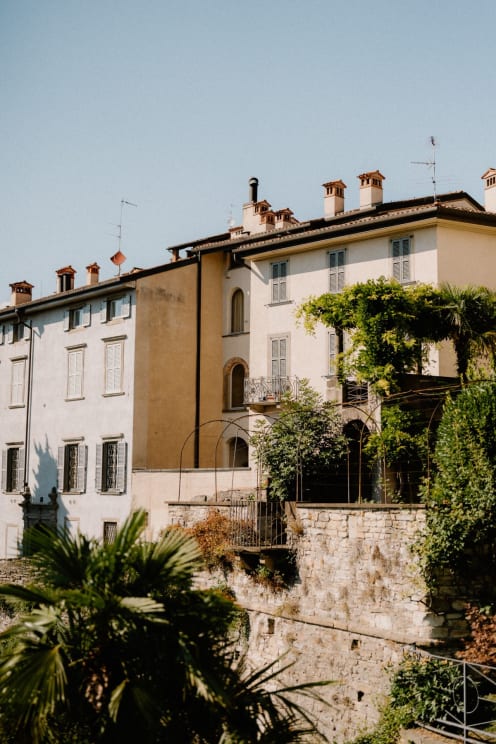 A Group Of Spanish Style Apartments Sit Above The Stone Wall