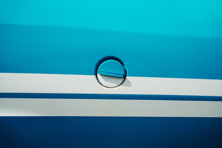Round Fuel Cap On A Blue And White Surface